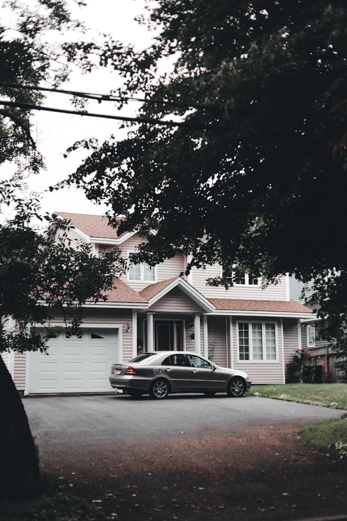 A modern suburban house with a parked car on the driveway with closed garage door unable to open.