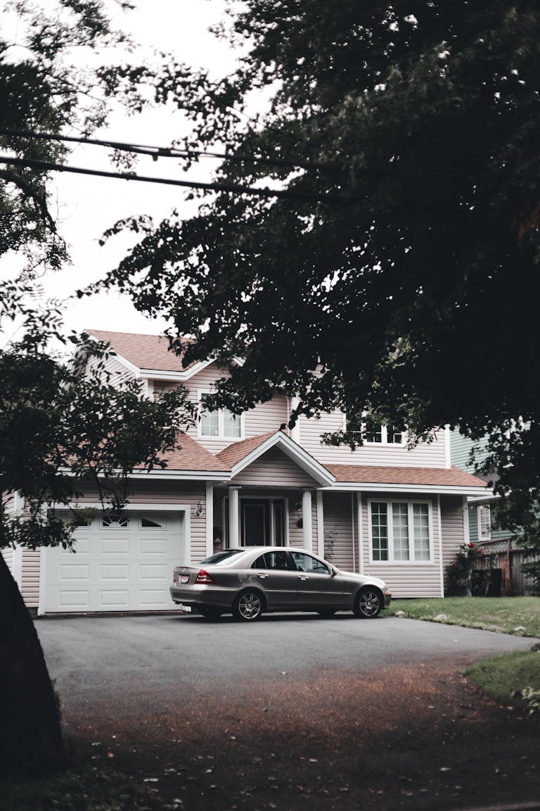 A modern suburban house with a parked car on the driveway with closed garage door unable to open.