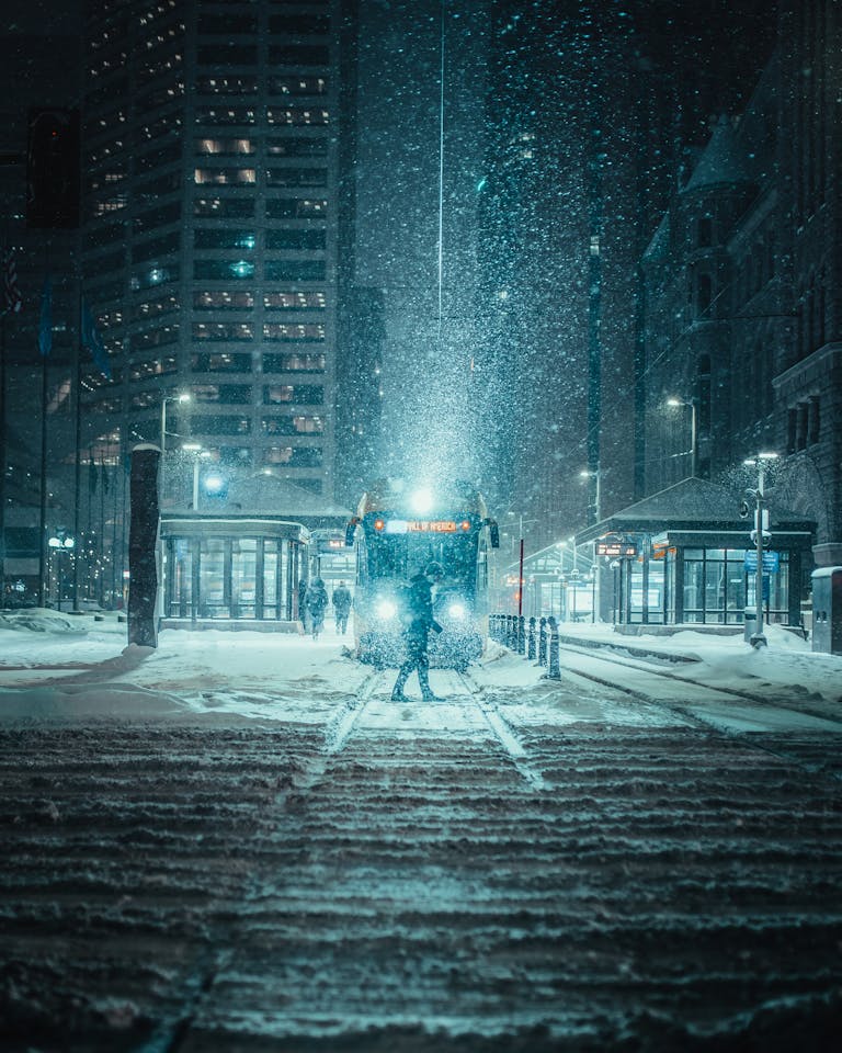 A snowy night scene with tram in downtown Minneapolis, highlighting urban winter charm.