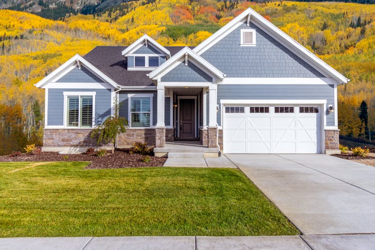 Beautiful suburban house with custom style garage doors featuring paned windows, wood trim accents and no hardware.