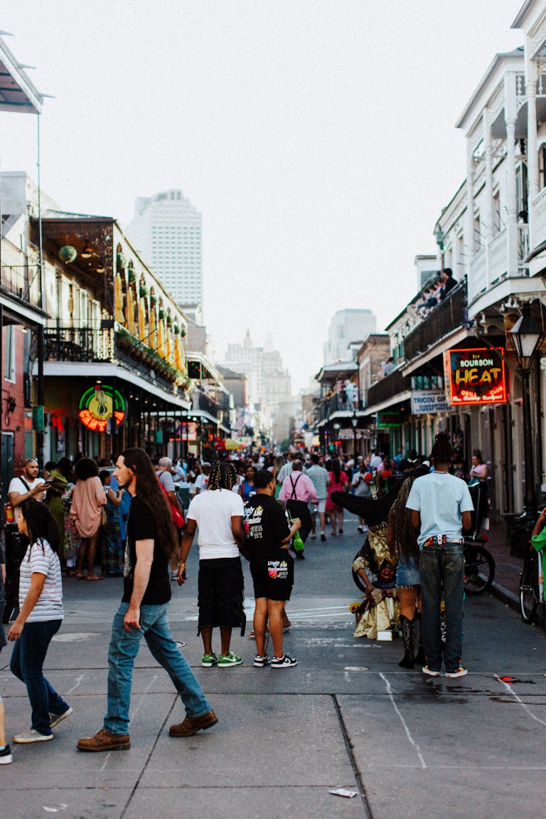 Bustling scene on Bourbon Street, New Orleans with a lively crowd enjoying an evening stroll.