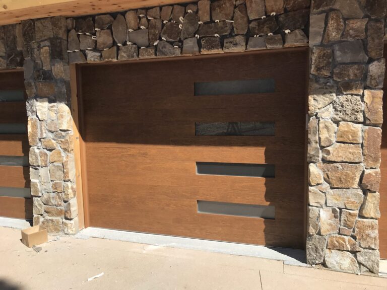 New Clopay modern garage doors featuring right side frosted glass inserts, 4 panels, faux wood, oak colored