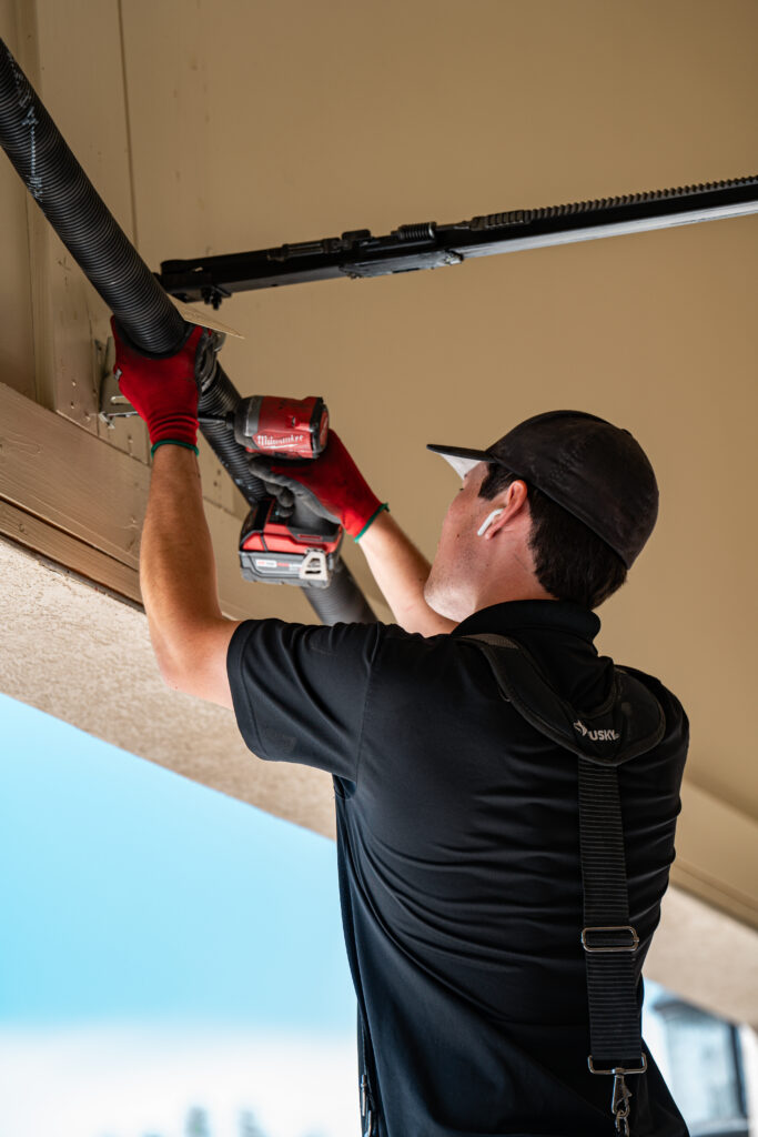 Local garage repairman fixing broken garage door springs