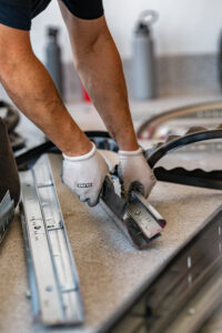 Man working on garage door chain and tracks to repair a loos chain and tighten tension