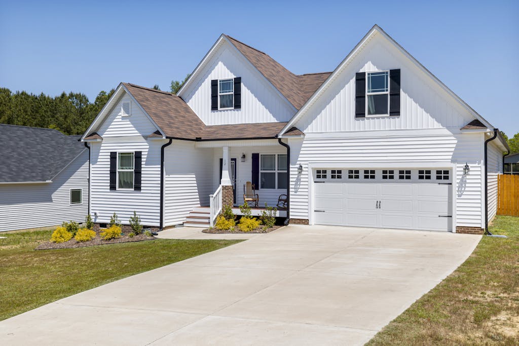 Elegant modern suburban home with garage and landscaped garden in daylight.