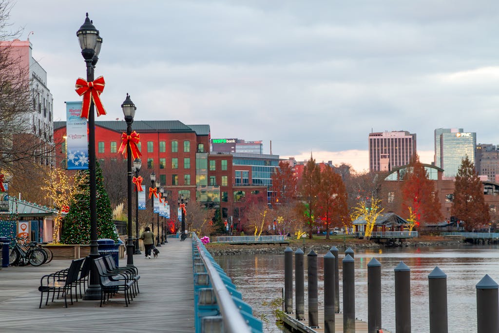 Festively decorated Wilmington, DE riverfront with holiday lights and bows along the walkway.