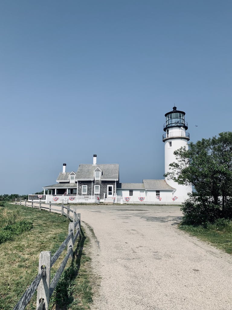 Highland Lighthouse and building in MA against a clear blue sky, a popular travel destination.