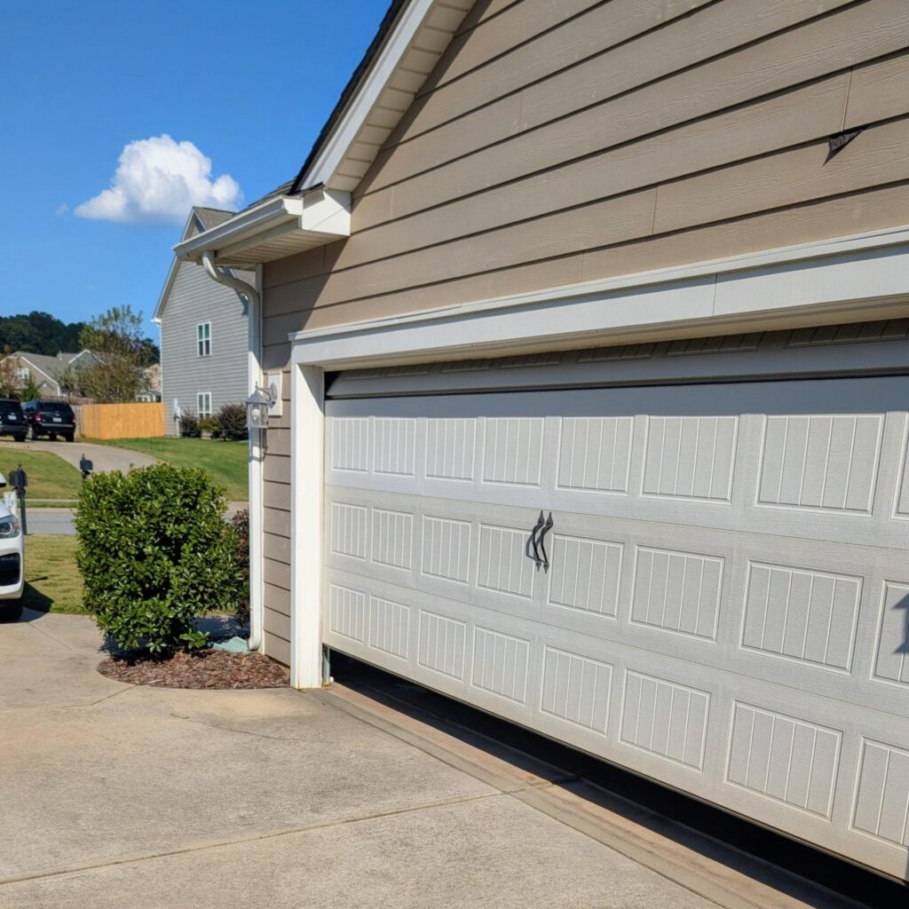 Stuck garage door on suburban home will not open or close completely.