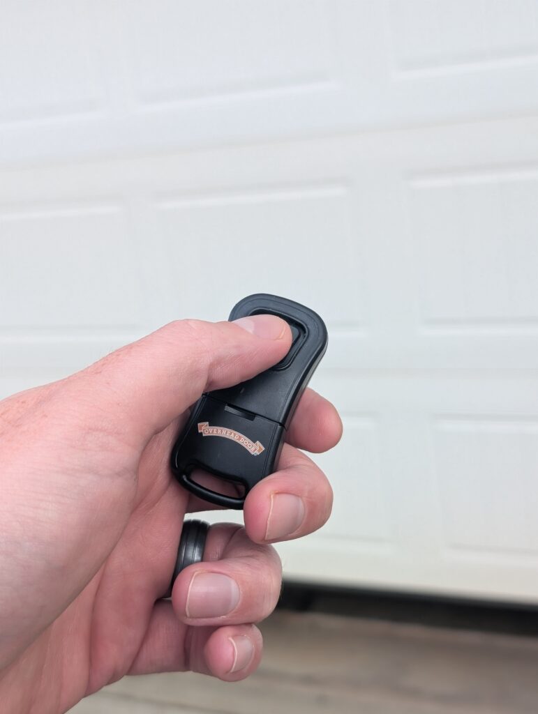 Homeowner opening garage with remote garage door opener form driveway