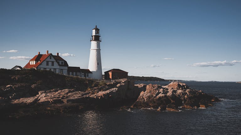 Scenic view of Portland Head Light, a famous lighthouse in Maine, along the rocky coastline.
