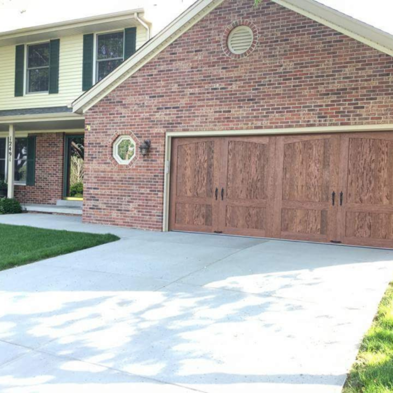 Older split level home with garage door replacement. New garage door displays improved curb appeal.
