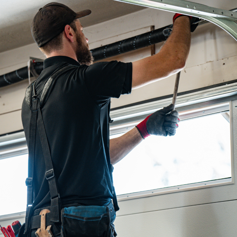 garage door service provider applying garage door lubrication to springs