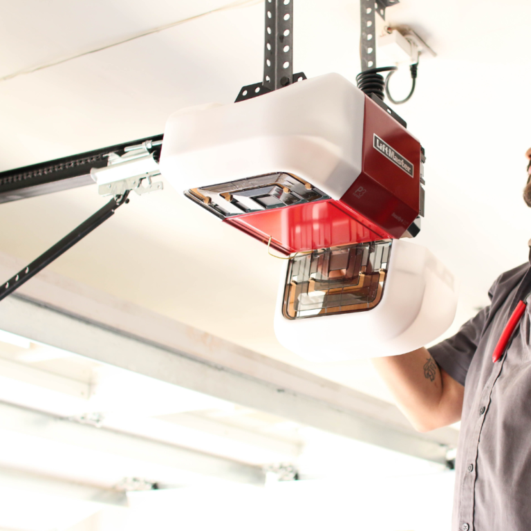 partially opened garage door with garage service pro working on the opener